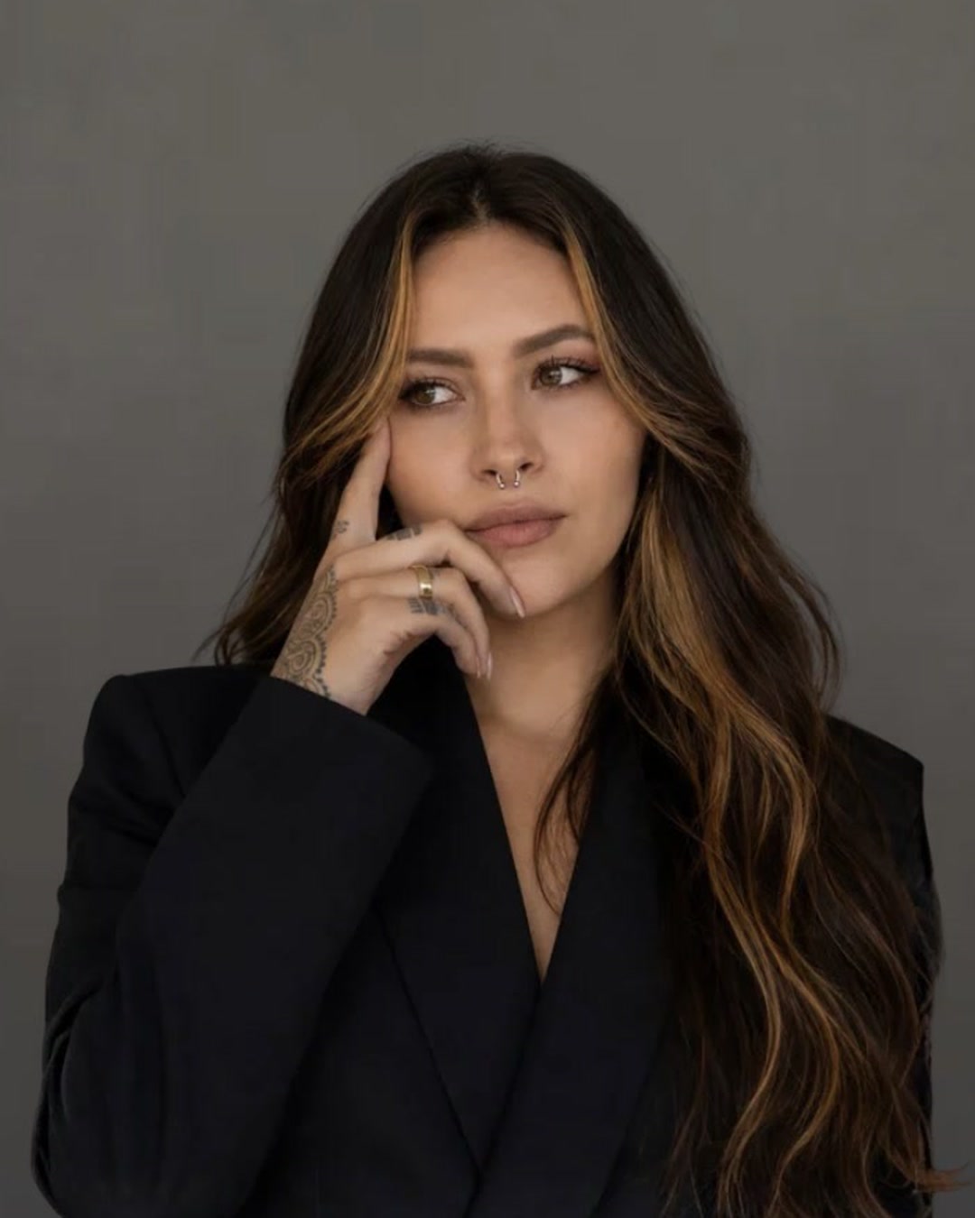 Amanda Schleweis de blazer preto, com a mão no queixo